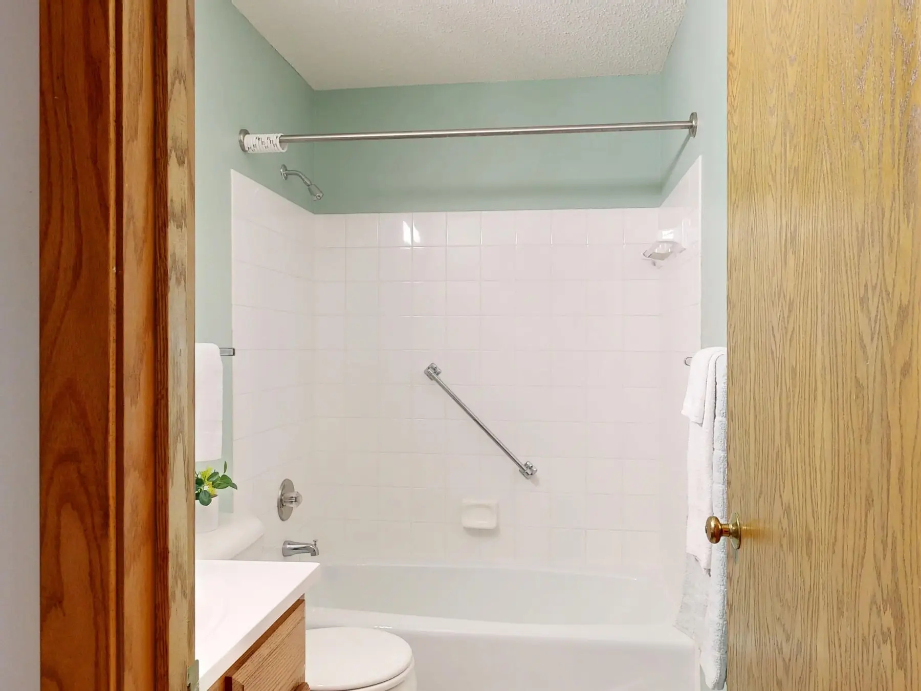 A bathroom with a grab rail fitted beside the bath