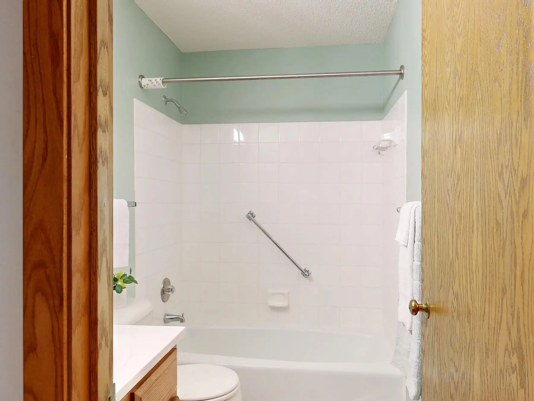 A bathroom with a grab rail fitted beside the bath