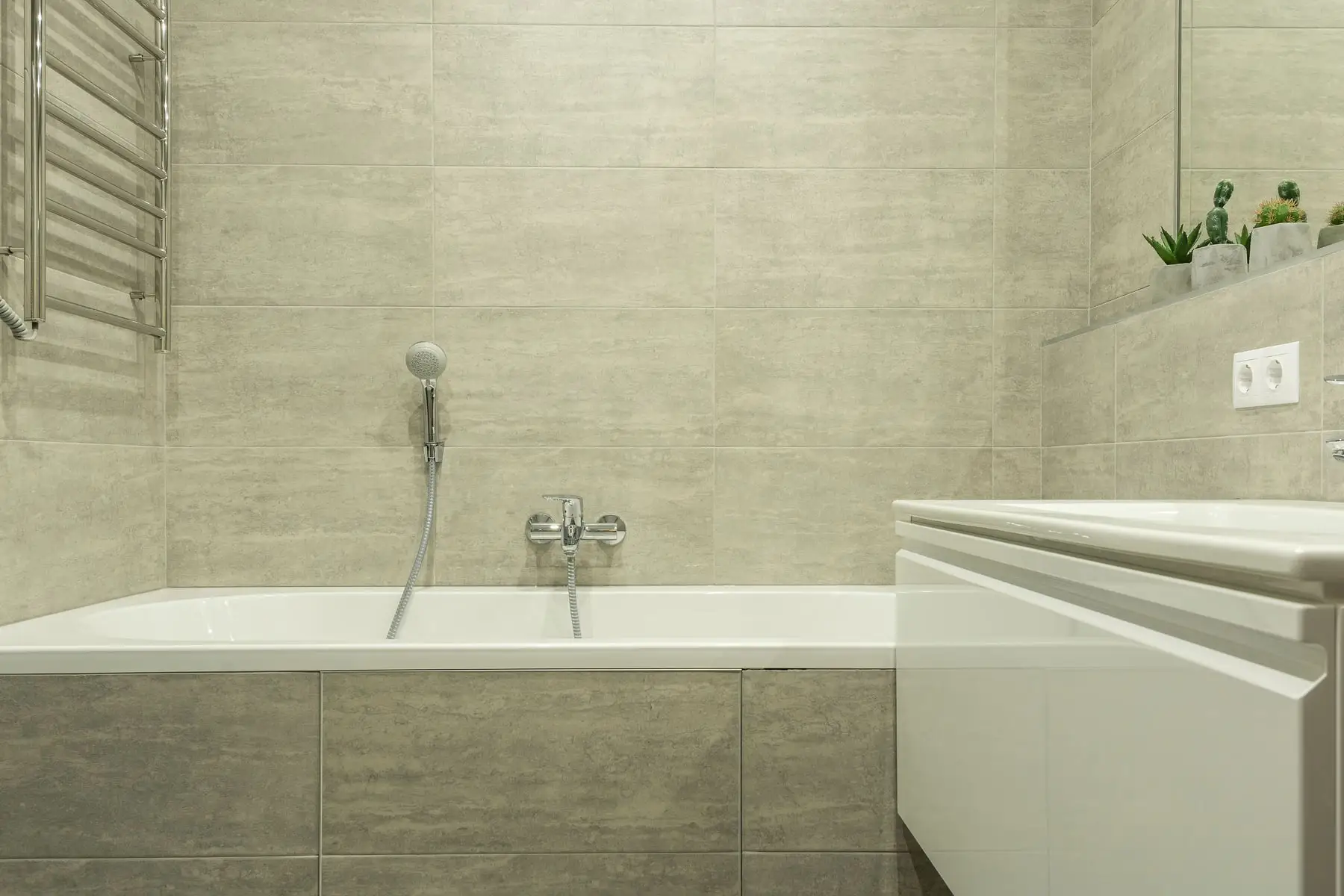 A renovated bathroom with freestanding bath and full-height tiling