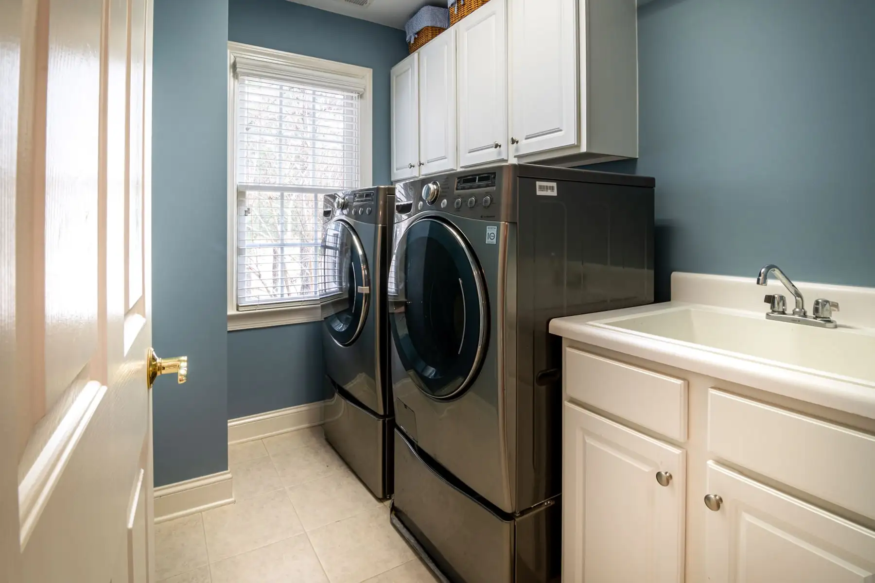 A fitted laundry with cabinets over the machines