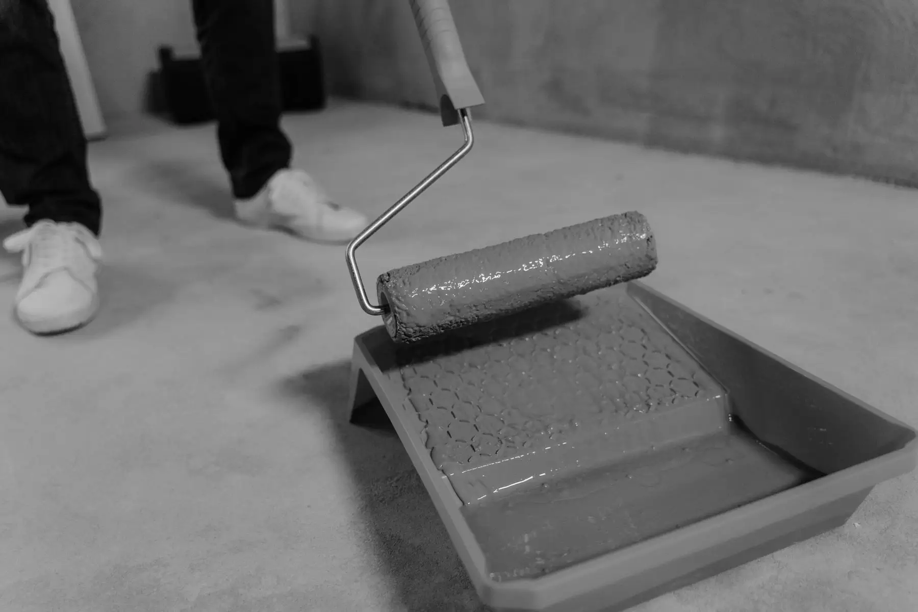 A waterproofing coat being rolled across a floor